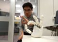 Wristband enables wearers to control a robotic hand with their own movements | MIT News